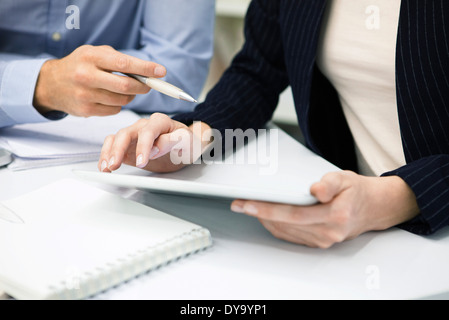 Colleagues using digital tablet, cropped Stock Photo