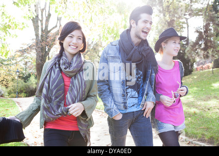 Friends walking together in park Stock Photo