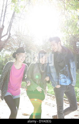 Friends walking together through park Stock Photo