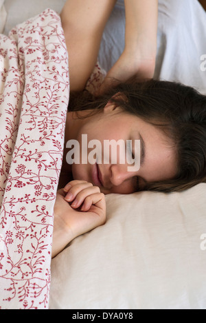 Woman relaxing in bed, cropped Stock Photo