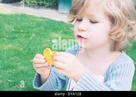 Little girl eating macaroon Stock Photo