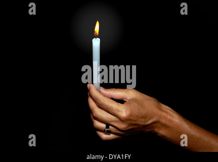 view of women’s hand holding candle in the dark Stock Photo