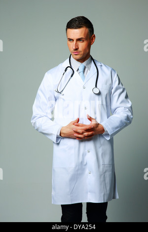 Portrait of a pensive male doctor on gray background Stock Photo