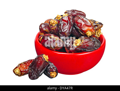 Dates in red ceramic bowl, isolated on a white background Stock Photo