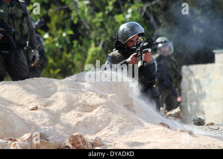 RAMALLAH, PALESTINE - APRIL 11: An Israeli border guard fired a rubber bullet at Palestinian protesters during a protest against the Jewish settlement of Ofra, in the West Bank village of Silwad, near Ramallah April 11, 2014. (Photo By Abdalkarim Museitef/Pacific Press) Stock Photo