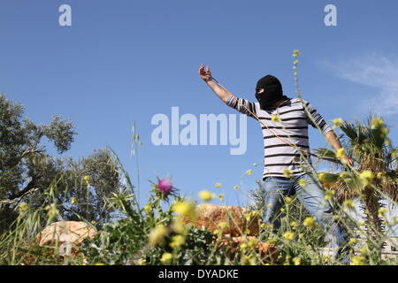 RAMALLAH, PALESTINE - APRIL 11: A Palestinian protester waves to Isreali soders during a protest against the Jewish settlement of Ofra, in the West Bank village of Silwad, near Ramallah April 11, 2014. (Photo By Abdalkarim Museitef/Pacific Press) Stock Photo