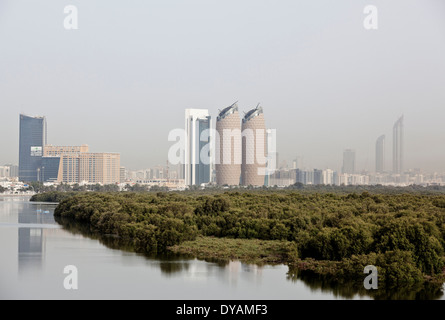 Al Bahar Tower and the city of Abu Dhabi stand above the mangroves, seen from Al Salam Street in Abu Dhabi. Stock Photo