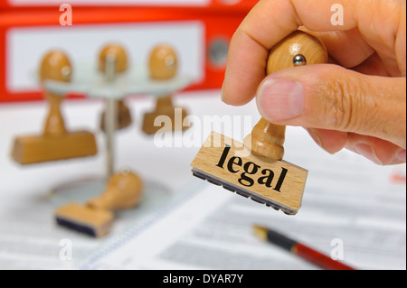 legal marked on rubber stamp in hand Stock Photo