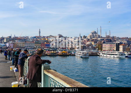 Fishermen on the Galata Bridge with the Eminonu waterfront behind, Istanbul, Turkey Stock Photo