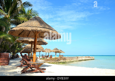 Chairs and umbrella on a beach with shadow from palm tree Stock Photo
