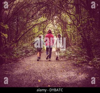 Mother and children walk in woods Stock Photo