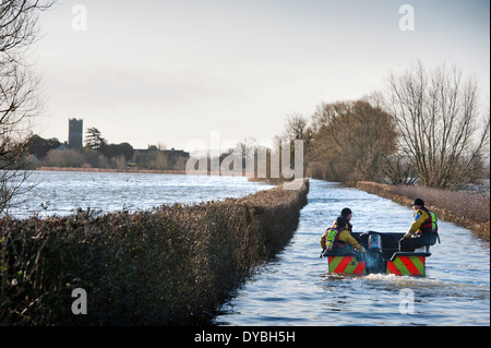 Flooding on the Somerset Levels - a flood rescue team operate a boat between Langport and the cut off village of Muchelney Stock Photo