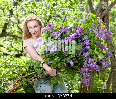 happy young woman in park with a big bouquet of a lilac Stock Photo