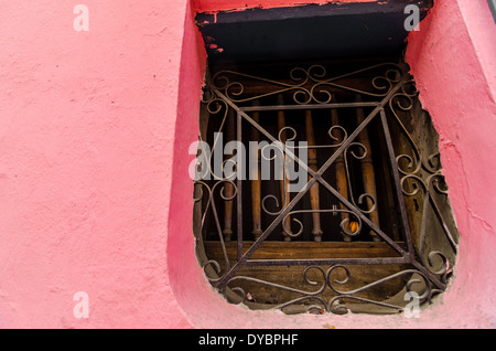 An old window on a pink wall in an old colonial building in La Candelaria neighborhood in Bogota, Colombia Stock Photo