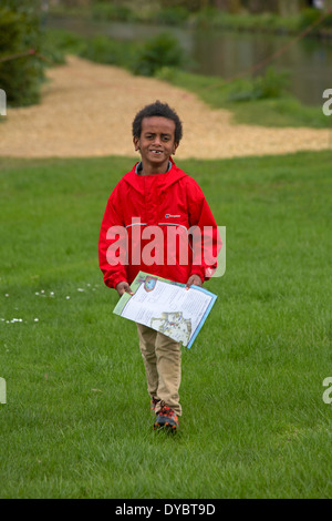 smiling young boy with missing front teeth walking and carrying Easter Egg hunt map