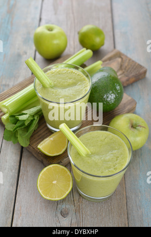 Smoothie of green apple, celery, avocado and lime on wooden background Stock Photo