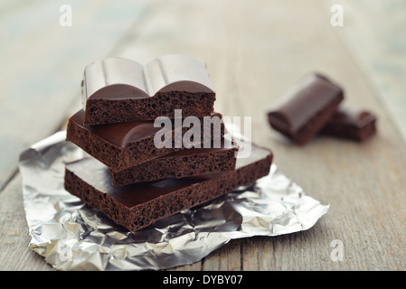 Porous chocolate in stack on a wooden background closeup Stock Photo