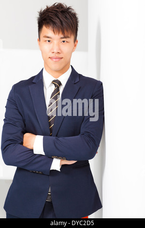 confident businessman cross arms with wall in studio Stock Photo