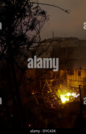 Valparaiso, Chile. 13th Apr, 2014. A house is burned during a fire in the Cerro Ramaditas in Valparaiso, Chile, on April 13, 2014. At least 11 people were killed over the weekend in a massive forest fire that broke out in Chile's port city of Valparaiso, authorities said Sunday. President Michelle Bachelet declared a state of emergency in the city and sent the army in to maintain order as thousands of residents were evacuated. Credit:  Str/Xinhua/Alamy Live News Stock Photo