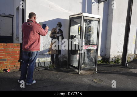 Cheltenham, UK . 14th Apr, 2014. Possible Banksy artwork outside a public telephone box satirising surveillance of citizens' conversations. Credit:  foto-call/Alamy Live News Stock Photo