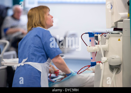 A nurse with a patient who is undergoing treatment for kidney disease on a kidney dialysis machine at a hospital Stock Photo