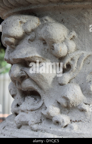 Ancient marble basrelief with an angry face Stock Photo