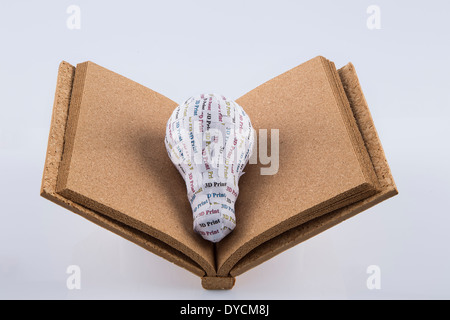 CYMK 3D Printing concept: lightbulb on blank cork book Stock Photo