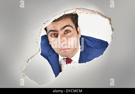 Man looking through a hole in the ceiling Stock Photo