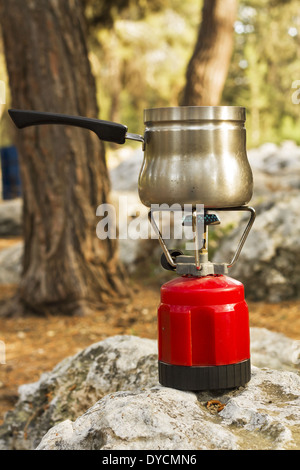 Making camping coffee from a geyser coffee maker on a gas burner,, autumn  outdoor. Male prepares coffee outdoors, travel activity for relaxing,  bushcr Stock Photo - Alamy