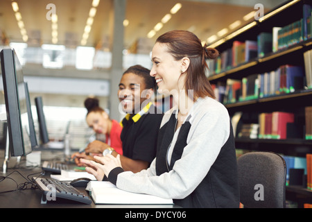 Multiethnic students sitting at table using computers for finding information for their study. Young university students. Stock Photo