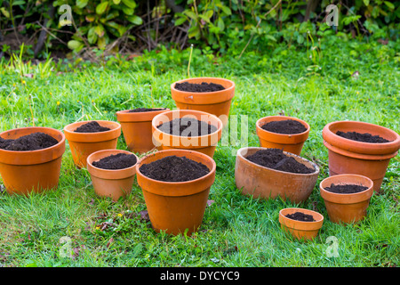 Fresh soil in terra cotta pots for a potted plant organic garden. Stock Photo