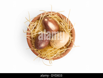 Mixed Easter eggs in a wooden bowl isolated on a white background. Stock Photo