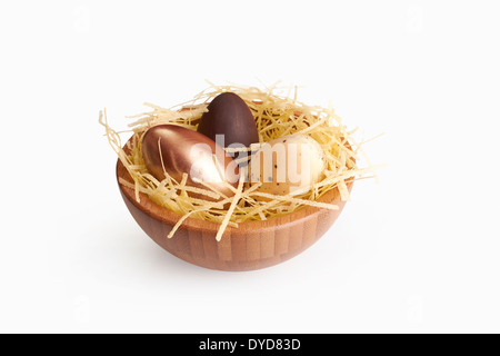 Mixed Easter eggs in a wooden bowl isolated on a white background. Stock Photo