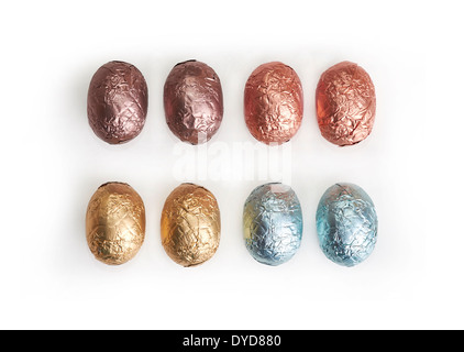 A Selection of chocolate Easter Eggs wrapped in coloured tin foil on a white background. Stock Photo