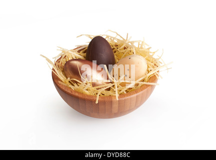 A wooden bowl of chocolate Easter Eggs on a white background. Stock Photo