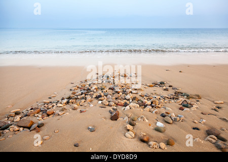 Atlantic ocean coast with wet small stones on the sand Stock Photo