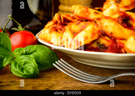 traditional tortellini pasta closeup with basil and tomato sauce Stock Photo