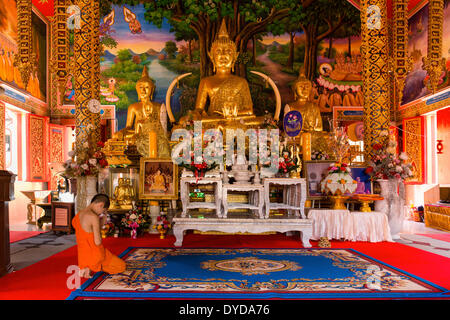 Monk, novice praying in front of a Buddha statue at Wat Sriboonruang, Sri Boon Ruang Temple, Chiang Rai, Northern Thailand Stock Photo