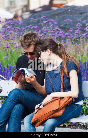 A couple of young tourists look at the Lonely Planet guide book in Prague. Stock Photo