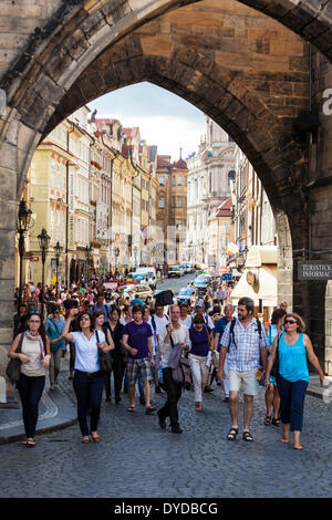 Hordes of tourists walking onto Charles Bridge in Prague at the Mala Strana end. Stock Photo