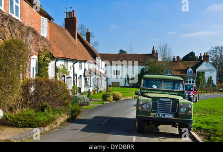 An old Land Rover outside ancient cottages in the historic town of Kenilworth in the green heart of Warwickshire. Stock Photo