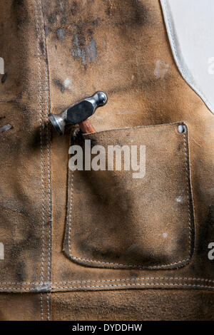 Leather workshop apron with a chasing hammer in the pocket. Stock Photo