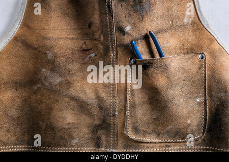 Leather workshop apron with pliers in the pocket. Stock Photo