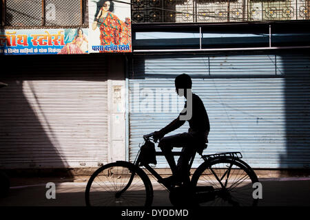 The silhouette of a boy on a bicycle. Stock Photo