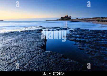 Looking towards Bamburgh Castle at dawn. Stock Photo