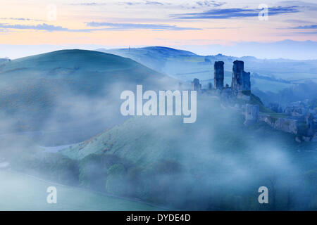 Corfe Castle in Dorset rising above early morning mist.