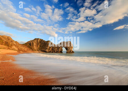 The natural Rock Arch of Durdle Door lit by the evening sun. Stock Photo