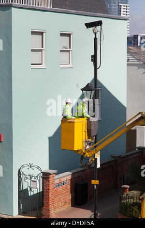 Street furniture maintenance workers using a cherry picker van to maintain street lights. Stock Photo