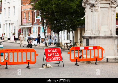 Road closed sign and barriers in town high street. Stock Photo