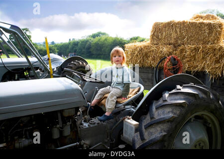 A two year old boy sitting on a tractor. Stock Photo